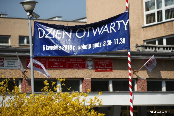 Na maszcie na flagę państwową powieszono banner reklamowy promujący dzień otwarty miejskiej szkoły.