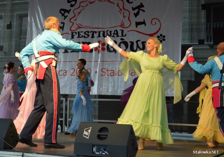 Elżbieta Żurawska w zielonkawej sukni tańczy poloneza na scenie na II Lasowiackim Festiwalu Pierogów w Stalowej Woli.