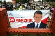 Wyborczy banner kandydata PiS na płocie cmentarza