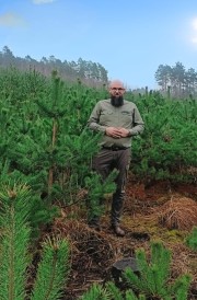 Grzegorz Tracz, specjalista Służby Leśnej ds. ochrony lasu w Nadleśnictwie Rozwadów wśród młodego pokolenia drzew.