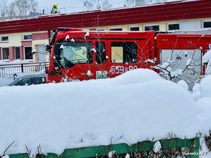 Strażacy usuwający śnieg z dachu miejskiego przedszkola nr 15 na ul. Obrońców Westerplatte 1 w Stalowej Woli.