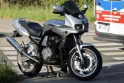 Zdarzenie drogowe z udziałem samochodu i motocykla na terenie strefy przemysłowej.