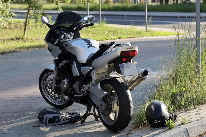 Zdarzenie drogowe z udziałem samochodu i motocykla na terenie strefy przemysłowej.