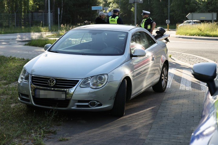 Zdarzenie drogowe z udziałem samochodu i motocykla na terenie strefy przemysłowej.