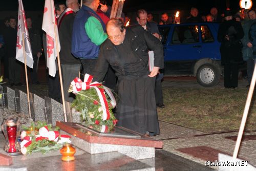 Ks. Jerzy Warchoł proboszcz parafii Opatrzności Bożej w Stalowej Woli składa kwiaty pod krzyżem przy HSW.