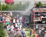 Dzieciaki miały ogromną frajdę, gdy z pompy strażackiej lał się z góry deszcz zimnej wody.