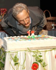 Zbigniew Kmiotek, zdobywca Złotej Pelargonii zdmuchuje świeczkę na urodzinowym torcie.